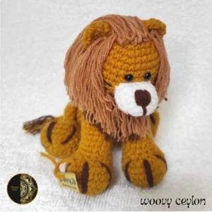 Handmade yellow crochet lion plush toy made from high quality milk-cotton yarn, displayed on a soft, neutral background.